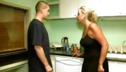 Fashionable housewife having fun with her young lover in the kitchen